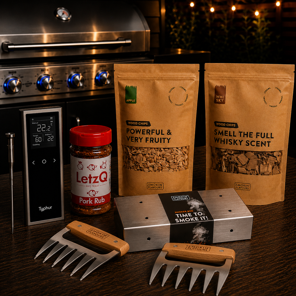 Ultimate Pulled Pork Gas Experience Bundle met Typhur Sync One, LetzQ Pork Rub, Smokin' Flavours appel- en whiskyrooksnippers, RVS smokerbox en meat claws op een houten tafel met gasbarbecue op de achtergrond.