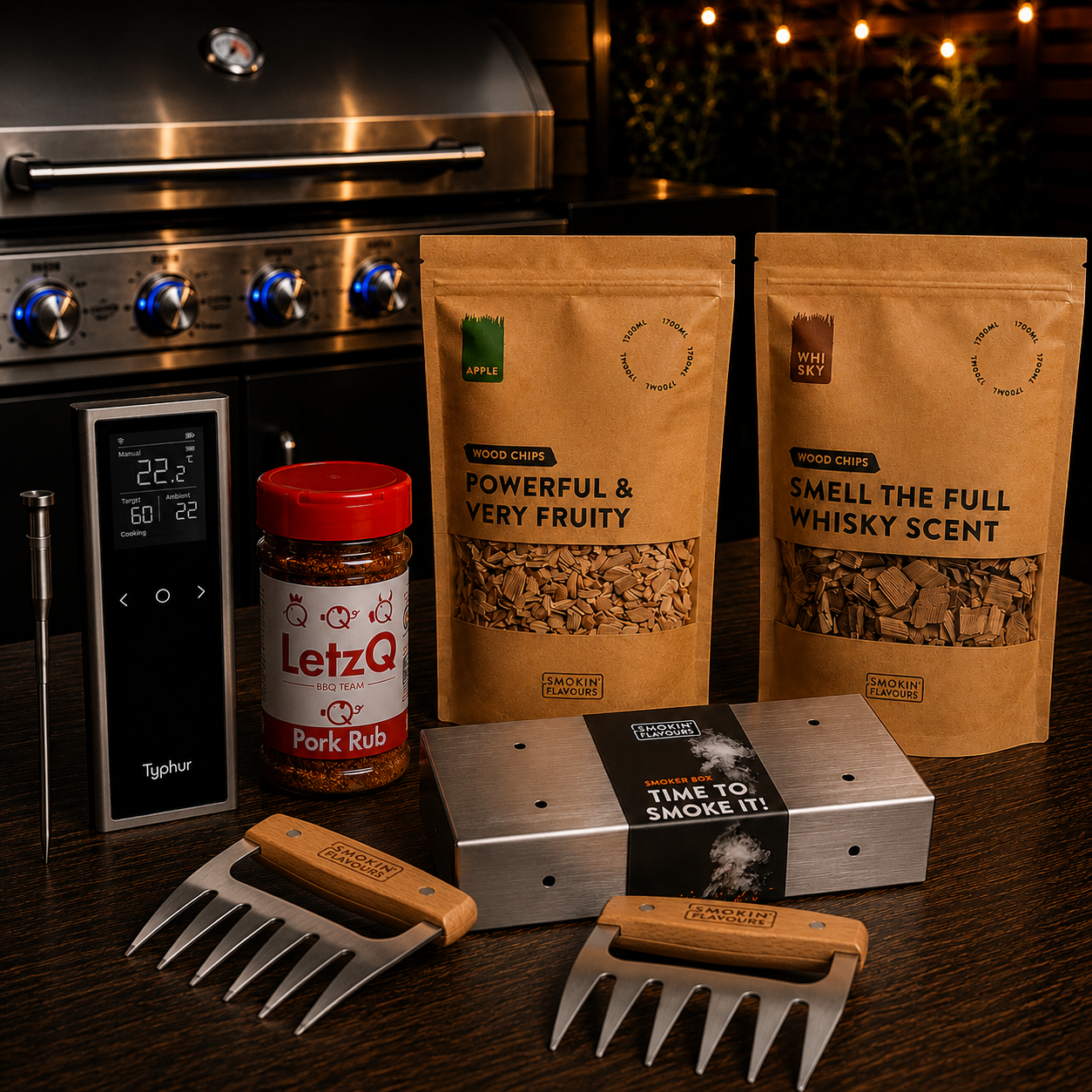 Ultimate Pulled Pork Gas Experience Bundle met Typhur Sync One, LetzQ Pork Rub, Smokin' Flavours appel- en whiskyrooksnippers, RVS smokerbox en meat claws op een houten tafel met gasbarbecue op de achtergrond.